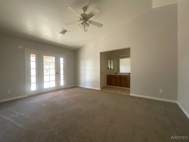 unfurnished room with ceiling fan, lofted ceiling, carpet flooring, visible vents, and baseboards