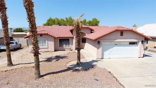 view of front of home featuring driveway, a tile roof, a garage, and stucco siding