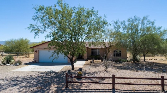 ranch-style home with concrete driveway, fence, an attached garage, and stucco siding