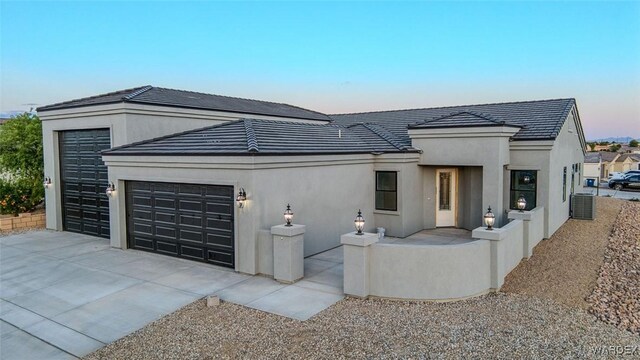 6068 S Greenhorn Dr, Fort Mohave, AZ 86426 - view of front of property featuring a garage, central AC, concrete driveway, and stucco siding
