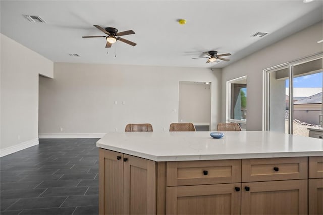 6068 S Greenhorn Dr, Fort Mohave, AZ 86426 - kitchen featuring a ceiling fan, baseboards, light countertops, a center island, and open floor plan