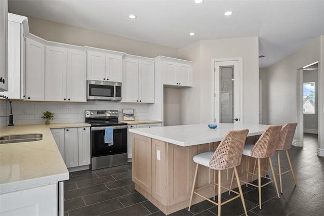 6068 S Greenhorn Dr, Fort Mohave, AZ 86426 - kitchen featuring appliances with stainless steel finishes, a sink, tasteful backsplash, a kitchen island, and recessed lighting