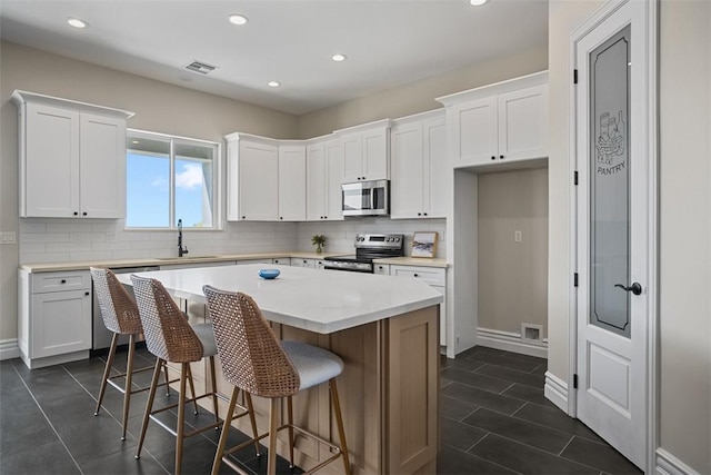 6068 S Greenhorn Dr, Fort Mohave, AZ 86426 - kitchen featuring stainless steel appliances, white cabinetry, decorative backsplash, a center island, and recessed lighting