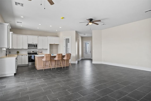 6068 S Greenhorn Dr, Fort Mohave, AZ 86426 - kitchen with appliances with stainless steel finishes, a ceiling fan, a sink, open floor plan, and recessed lighting