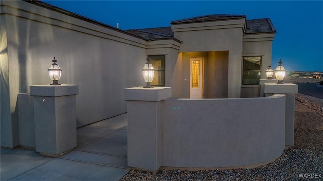 6068 S Greenhorn Dr, Fort Mohave, AZ 86426 - exterior entry at twilight featuring stucco siding and a tile roof