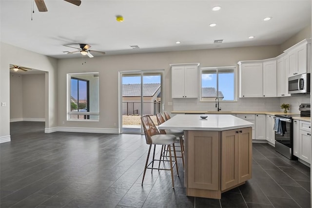6068 S Greenhorn Dr, Fort Mohave, AZ 86426 - kitchen featuring appliances with stainless steel finishes, a ceiling fan, recessed lighting, plenty of natural light, and backsplash