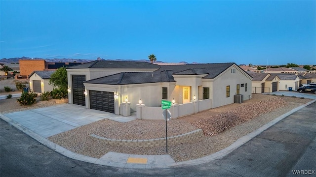 6068 S Greenhorn Dr, Fort Mohave, AZ 86426 - view of front of home with a garage, concrete driveway, stucco siding, central air condition unit, and a residential view