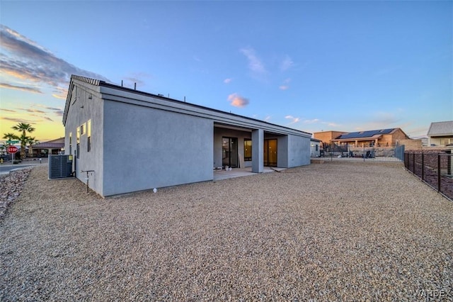 6068 S Greenhorn Dr, Fort Mohave, AZ 86426 - back of house at dusk featuring central AC unit and stucco siding