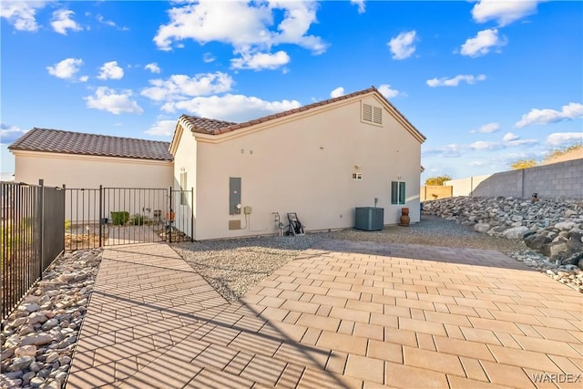 back of property featuring a fenced backyard, a tiled roof, a patio, and stucco siding