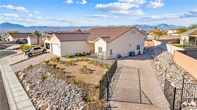 view of front facade with a fenced backyard, a residential view, a mountain view, and stucco siding