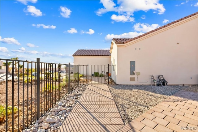 view of patio / terrace with electric panel, a gate, and fence