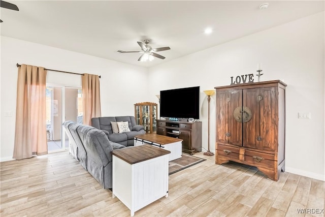 living room featuring ceiling fan, light wood finished floors, and baseboards