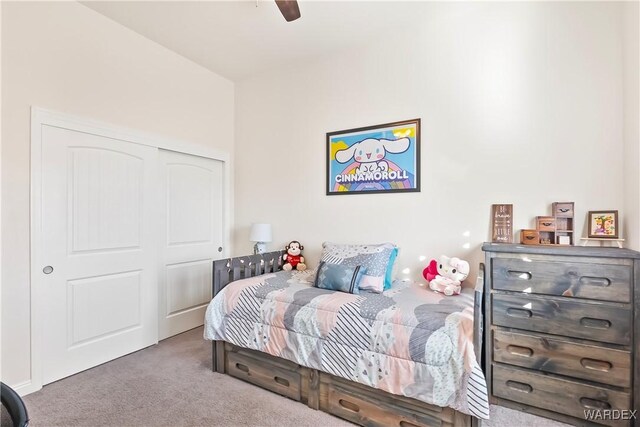 carpeted bedroom with ceiling fan and a closet