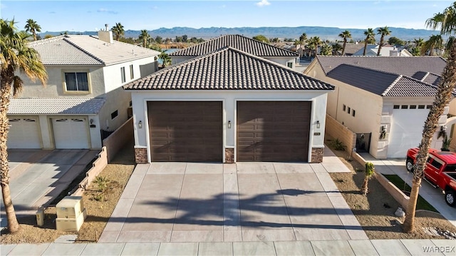 view of front of property featuring stone siding, a tile roof, and driveway