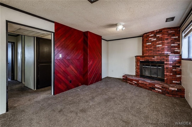 unfurnished living room featuring carpet flooring, a fireplace, visible vents, and a textured ceiling