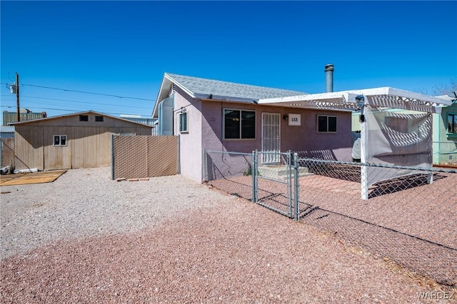 back of property with fence, roof with shingles, stucco siding, a pergola, and a gate