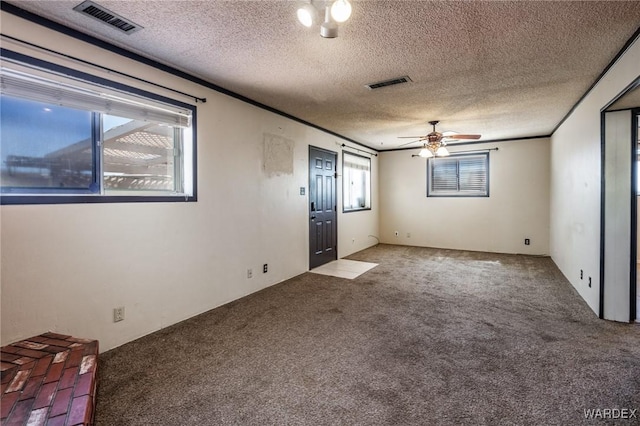 interior space with carpet flooring, visible vents, and ornamental molding