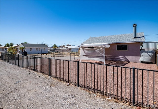 exterior space featuring fence private yard, roof with shingles, and stucco siding