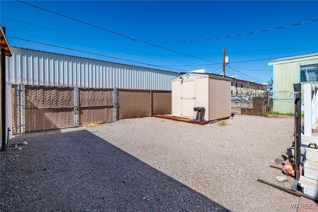 view of yard featuring a storage unit, an outdoor structure, and fence