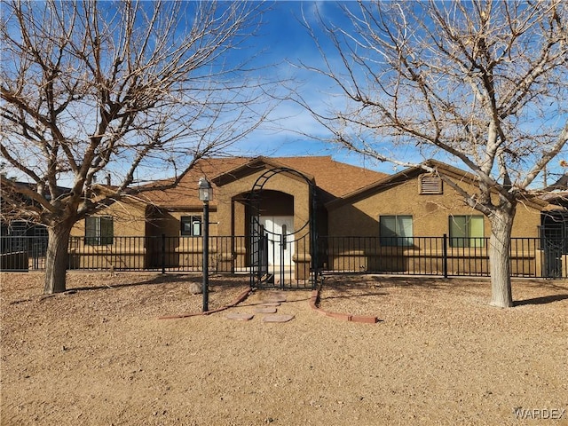 ranch-style house featuring a fenced front yard and stucco siding