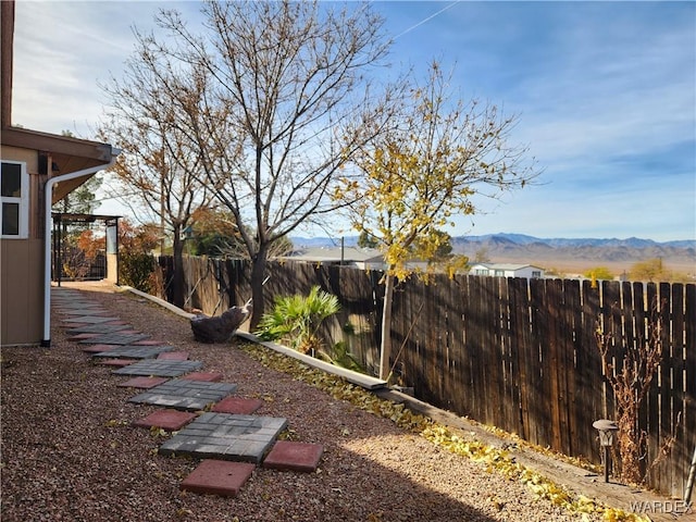 view of yard featuring a fenced backyard and a mountain view