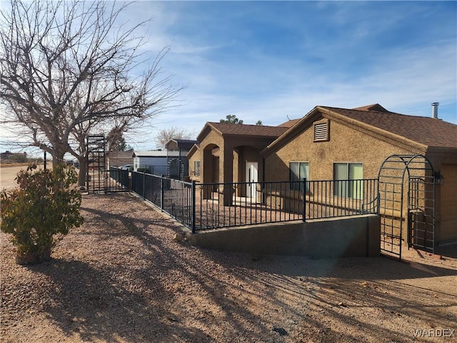 view of front of home with fence and stucco siding