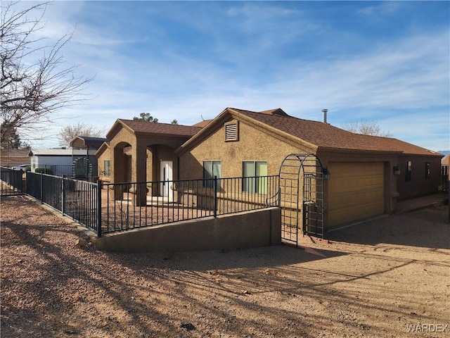 ranch-style house with driveway, a garage, fence, and stucco siding