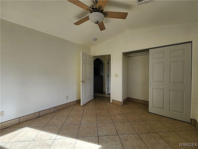 unfurnished bedroom with light tile patterned floors, ceiling fan, baseboards, and vaulted ceiling