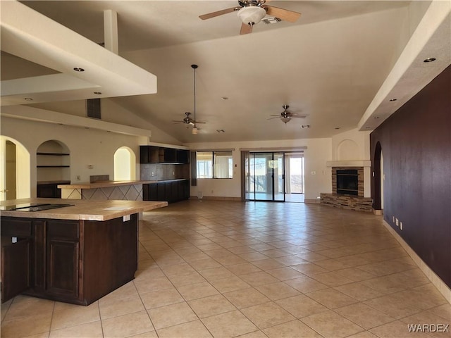 kitchen with light tile patterned floors, a ceiling fan, open floor plan, black electric stovetop, and light countertops