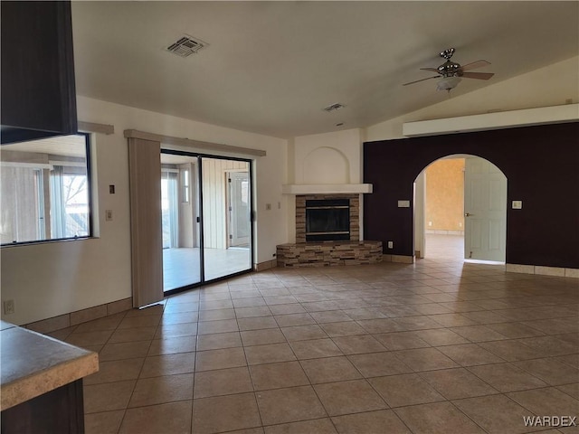 unfurnished living room featuring arched walkways, lofted ceiling, visible vents, a ceiling fan, and tile patterned floors