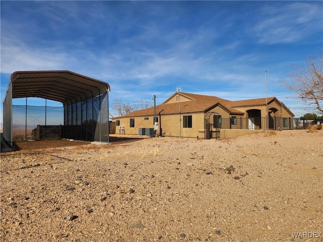 rear view of property featuring a detached carport and central air condition unit