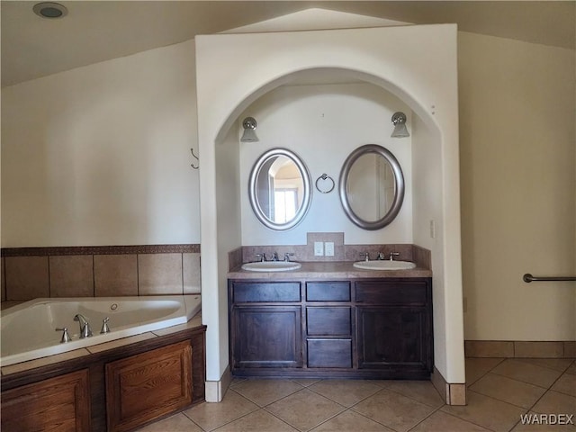 bathroom featuring double vanity, a sink, a bath, and tile patterned floors