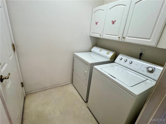 laundry room with baseboards, light floors, cabinet space, and washer and dryer