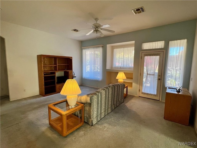 sitting room featuring carpet floors, visible vents, and a ceiling fan