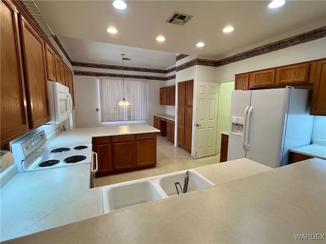 kitchen with light countertops, white appliances, a peninsula, and hanging light fixtures