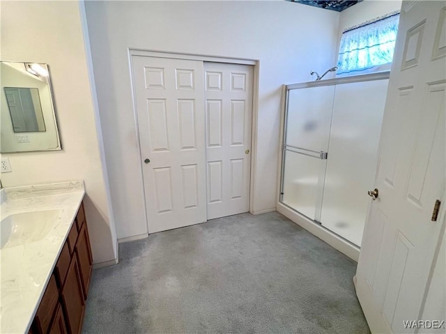 bathroom with carpet floors, a stall shower, and vanity