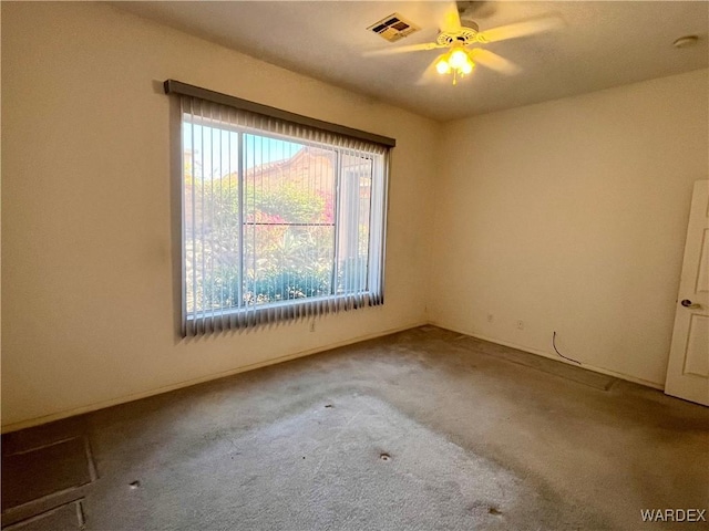 carpeted empty room featuring visible vents