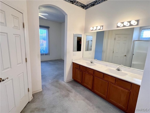 full bathroom featuring carpet floors, a healthy amount of sunlight, and a sink