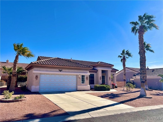 mediterranean / spanish-style house featuring a garage, driveway, a tiled roof, and stucco siding