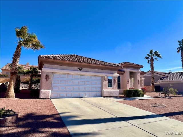 mediterranean / spanish-style house featuring a garage, driveway, a tiled roof, and stucco siding