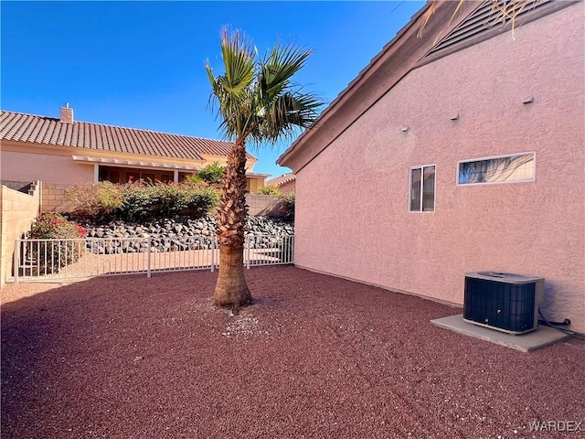 view of yard featuring central AC and fence