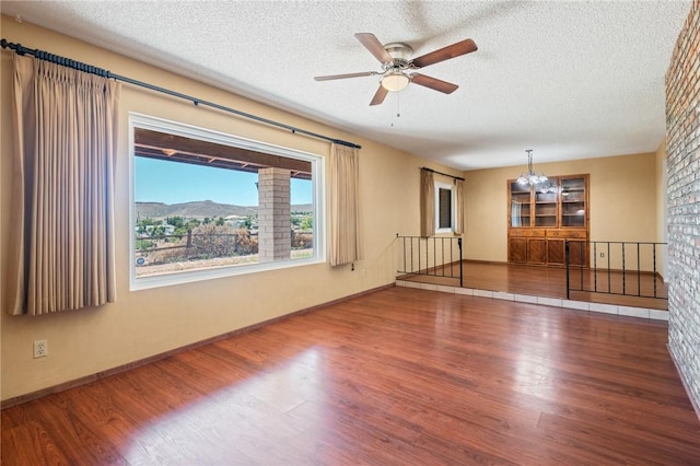 898 Crestwood Ln, Kingman, AZ 86409 - unfurnished room with wood finished floors, a chandelier, a textured ceiling, and ceiling fan