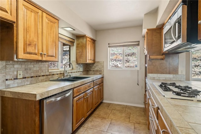 898 Crestwood Ln, Kingman, AZ 86409 - kitchen with stainless steel appliances, tasteful backsplash, tile countertops, and brown cabinets