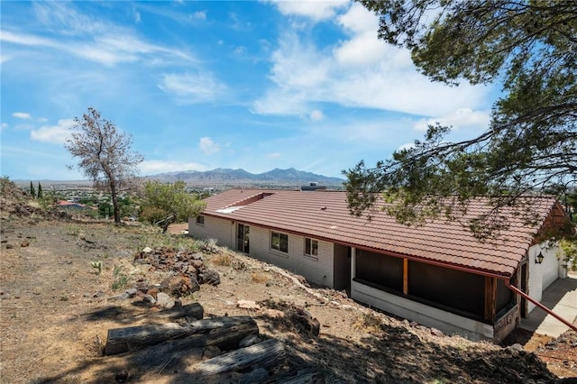 898 Crestwood Ln, Kingman, AZ 86409 - rear view of property featuring a tile roof, a mountain view, a sunroom, and a garage