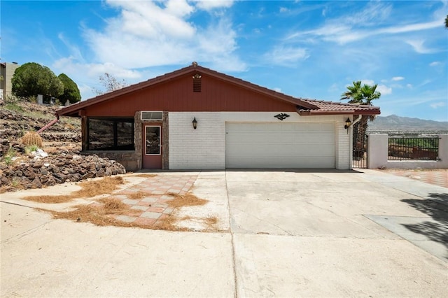 898 Crestwood Ln, Kingman, AZ 86409 - ranch-style home featuring driveway, an attached garage, brick siding, and a tile roof