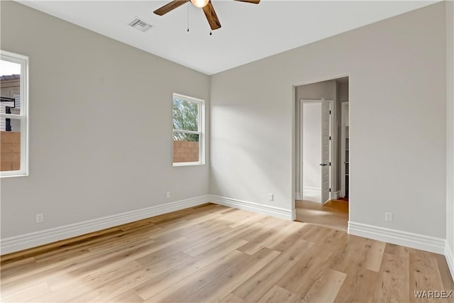 unfurnished room featuring light wood-type flooring, baseboards, visible vents, and a ceiling fan