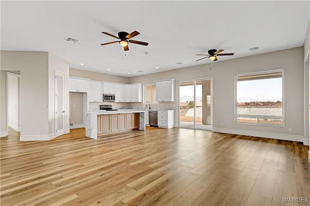 unfurnished living room with light wood finished floors, recessed lighting, visible vents, and baseboards