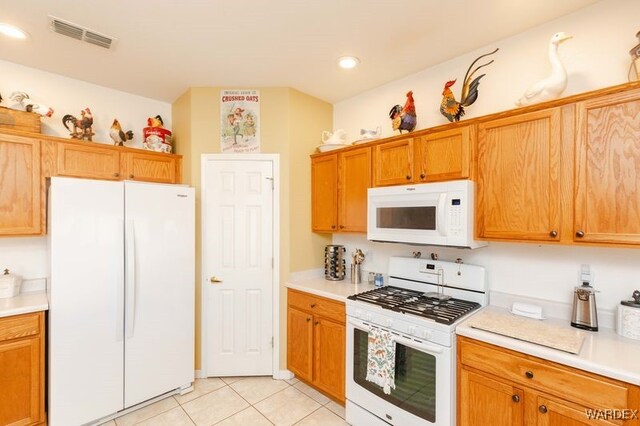 kitchen featuring light countertops, white appliances, visible vents, and light tile patterned floors