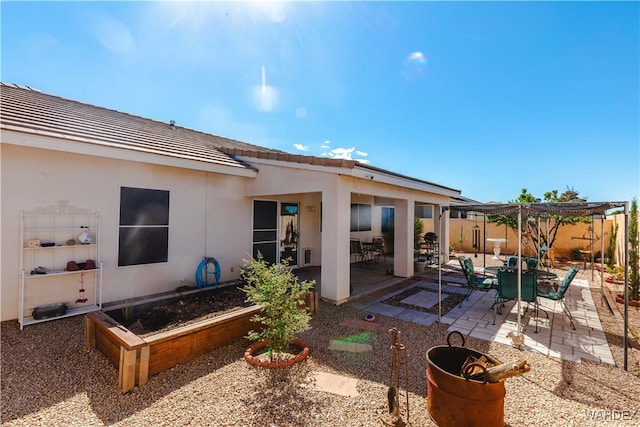 rear view of property featuring stucco siding and a patio