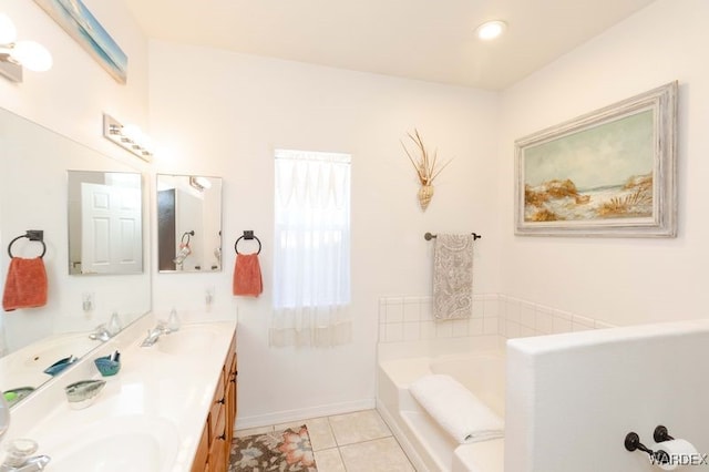 bathroom with double vanity, tile patterned flooring, a sink, and a bath